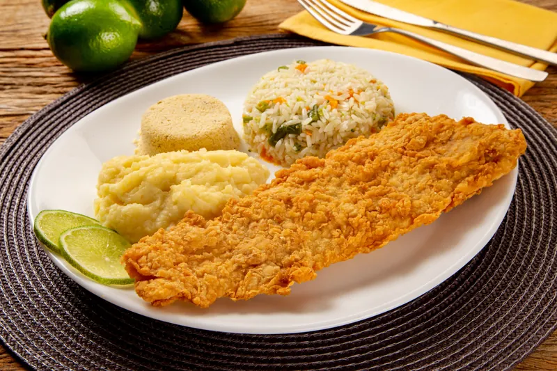 Merluza empanada com purê, arroz e limão